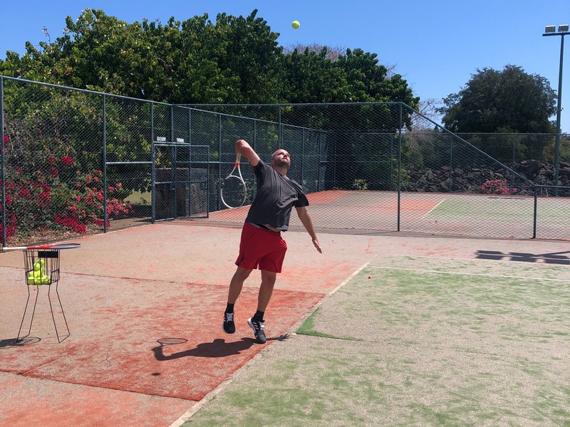 Guy playing tennis in Mauritius at Tamarina